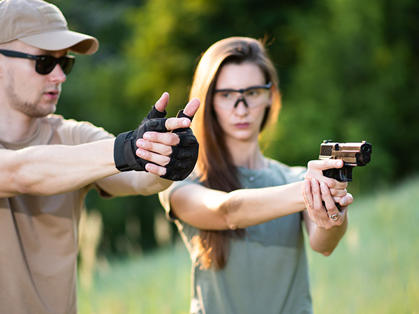 Zoom Defense - man showing a woman how to handle a gun